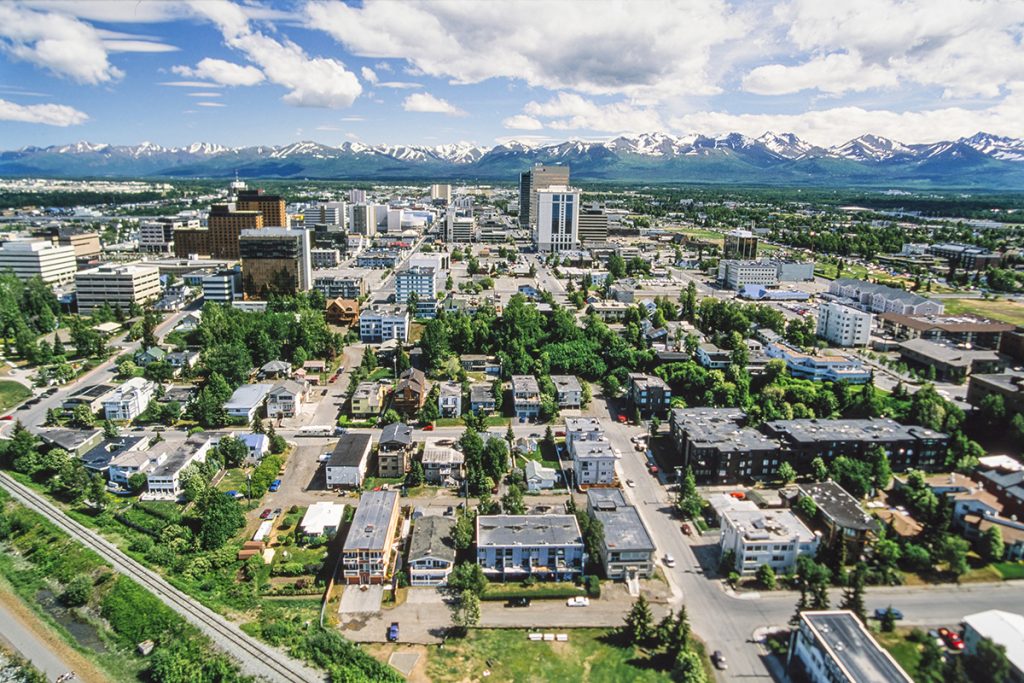 small houses in the city of anchorage alaska with snowy mountains in the back